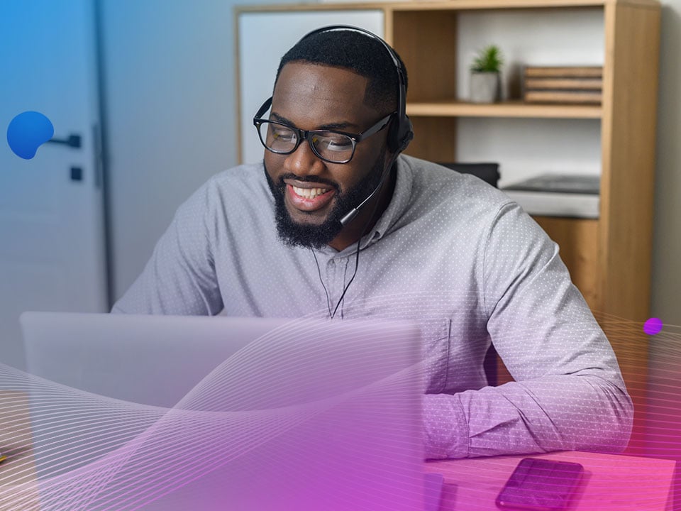 An office worker in the telecommunications industry uses customer experience software on his computer. 