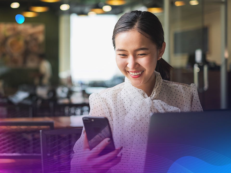 Woman using mobile phone and laptop to manage ad experiences