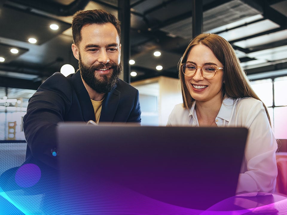 Coworkers using a customer experience solution on their computer to streamline production 