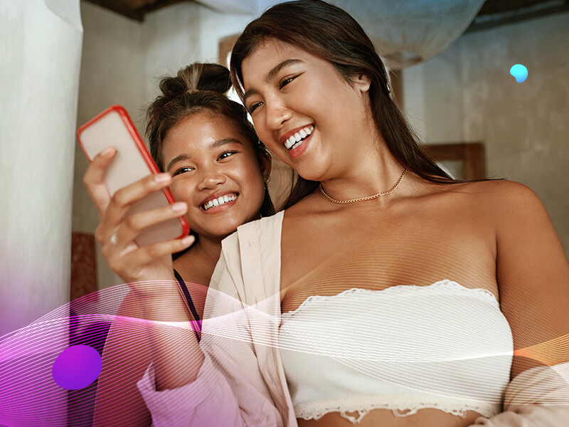 Two women looking at phone and smiling