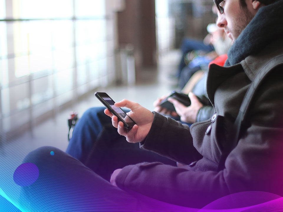 Traveler in airport reading a dynamic email on smartphone